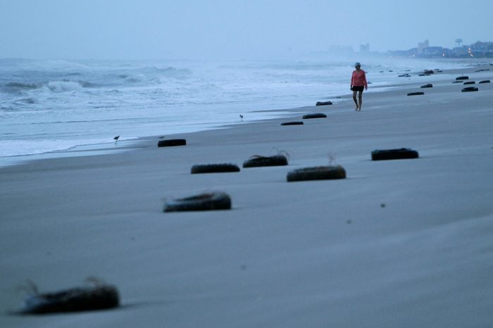 A woman walks on the beach past tires washed up after Hurricane Earl brushed the North Carolina coast in Atlantic Beach, N.C