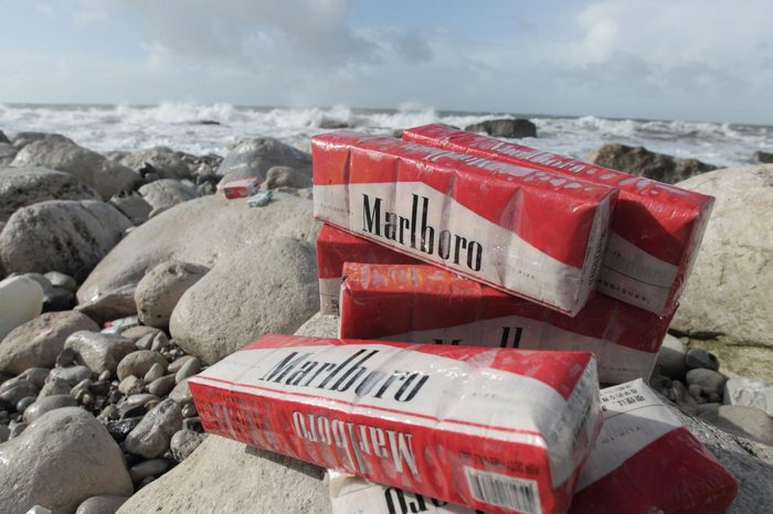 Cigarettes washed up on beach after container spill, Isle of Portland, Dorset, England, February 2014
