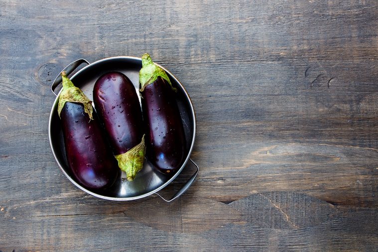 Fresh eggplants on dark wooden background.. Vegetarian food, health or cooking concept.