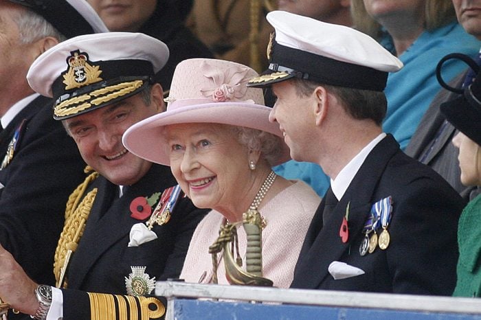 Queen Elizabeth II smiles as she sits with Captain Jerry Kyd (R) Commanding officer of HMS Ark Royal and Admiral Sir Trevor Soar Commander-in-Chief Fleet (L).