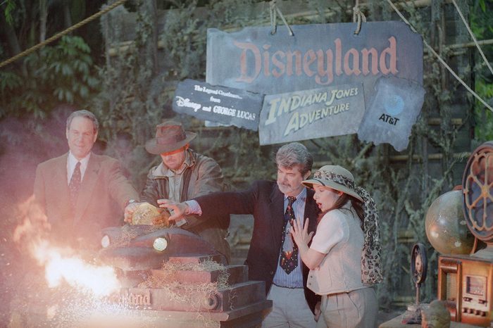 Disney chief Michael Eisner, left, and director George Lucas, second from right, are assisted by actors portraying Indiana Jones and Jones' assistant, as they officially open the Indiana Jones adventure attraction at Disneyland in Anaheim, California