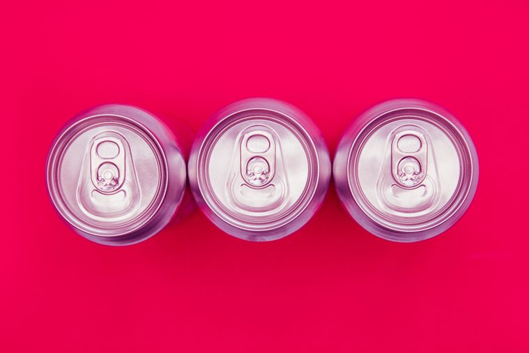 Silver metal energy drinks cans on bright pink background