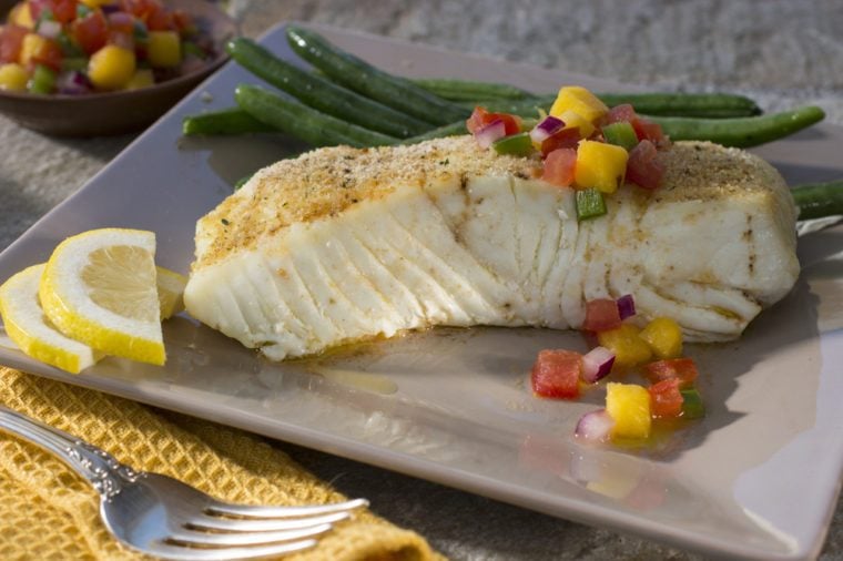 Alaskan Halibut on Dinner Plate with Green Beans and Lemon Slices