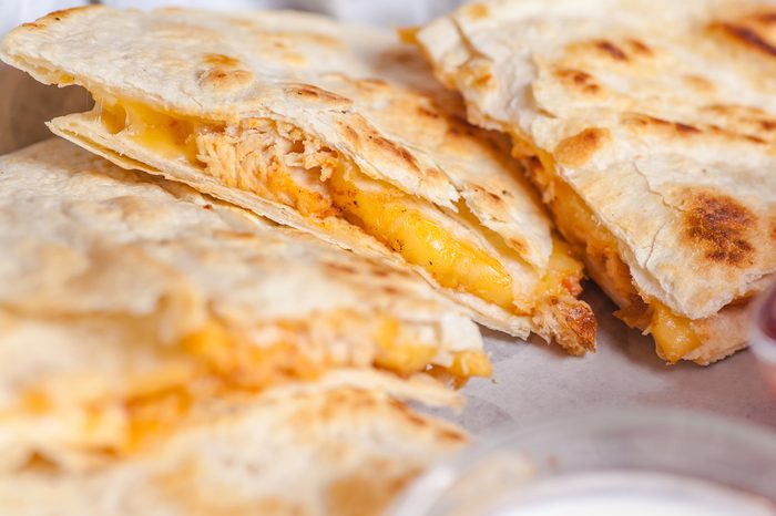 Close up shot of several freshly served cheese quesadillas on a platter