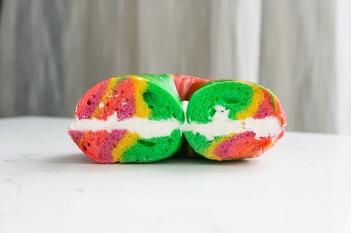 side photo of rainbow bagel with cream cheese