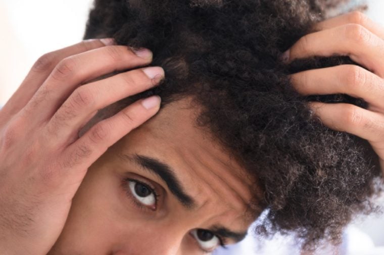 Close-up Of A Young Man Examining His Hair