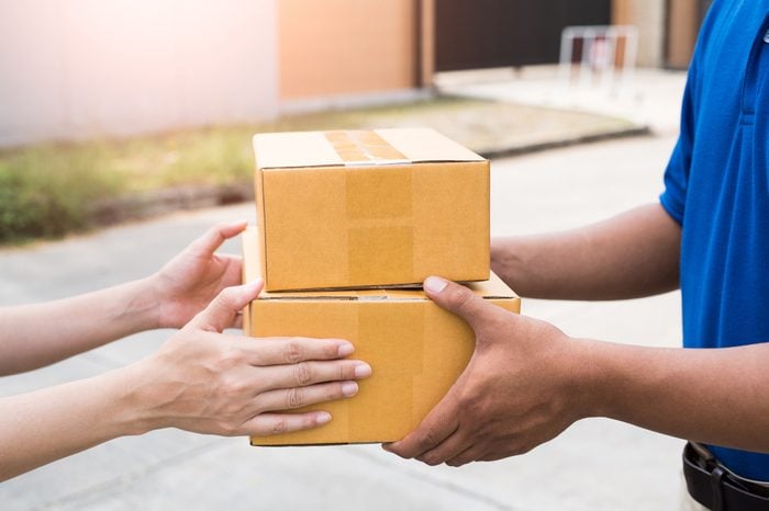 Women hands receiving package from delivery man.