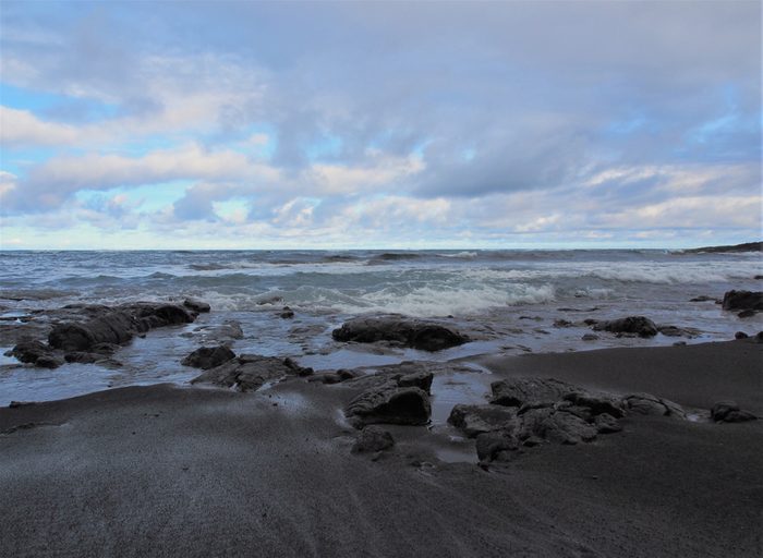 Punalu'u Black Sand Beach with Calm Waves, Rocks, and Cloudy Blue Sky, The Big Island, Hawaii
