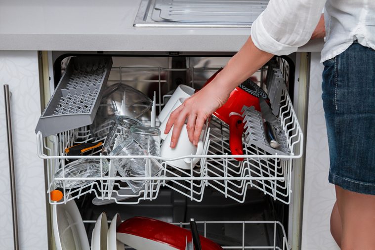 Elegant woman washing dishes in the dishwasher.