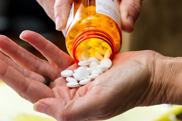 close up of a hand handling prescriptions pills as a concept