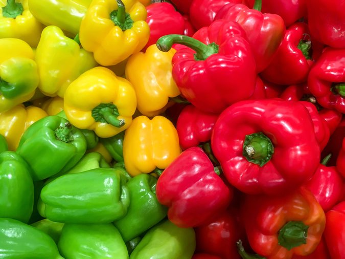 Food background - Pile of ripe red and green bell pepper close-up
