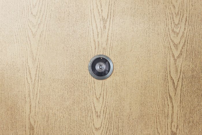 door lens peephole on light wooden texture