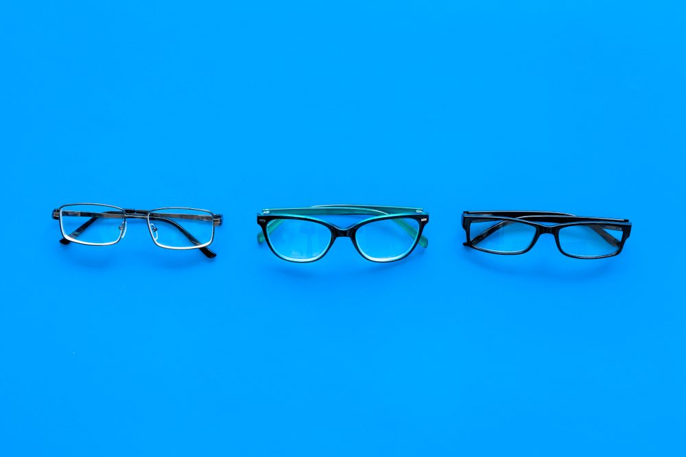 Glasses concept. Set of glasses with different eyeglass frame and transparent lenses on blue background top view copy space pattern