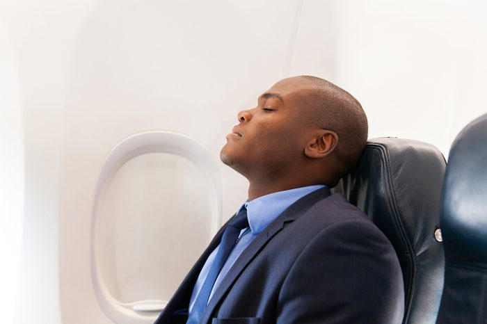 handsome african businessman resting on airplane