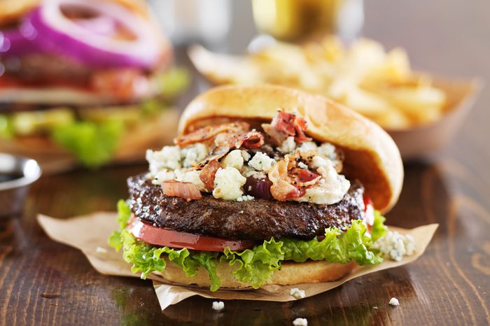 gourmet burgers on wooden table with bleu cheese and bacon