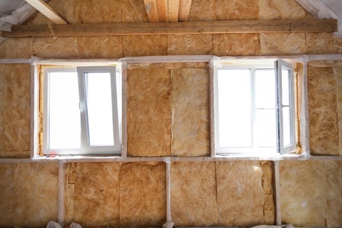 Inside wall heat isolation with mineral wool in wooden house, building under construction 