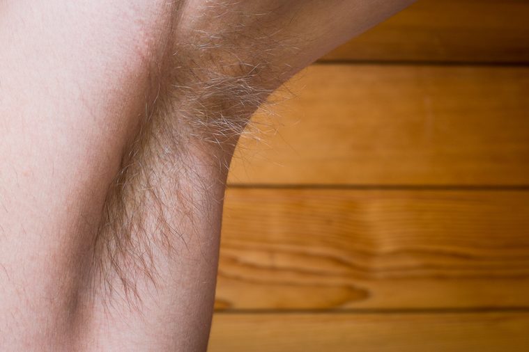 Young Guy's Hairy Underarm on Wooden Background