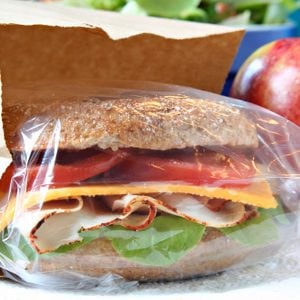 Whole grain sandwich in a brown paper lunch bag.