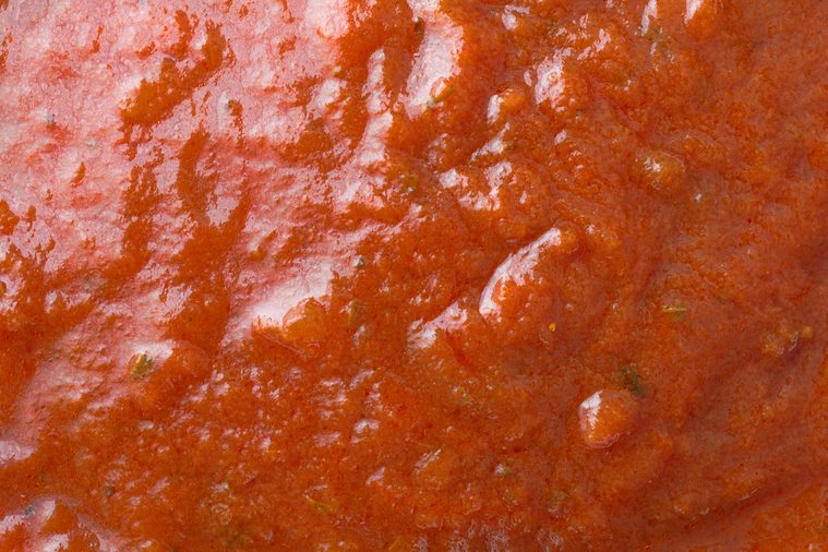A very close view of marinara sauce illuminated with window light.