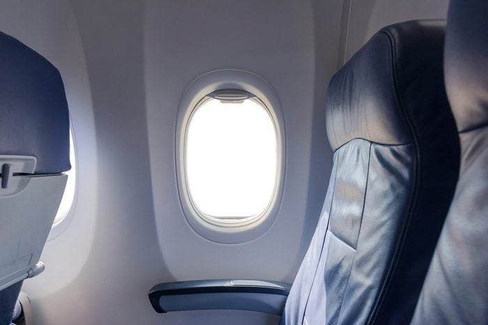Airplane seat with white empty window.