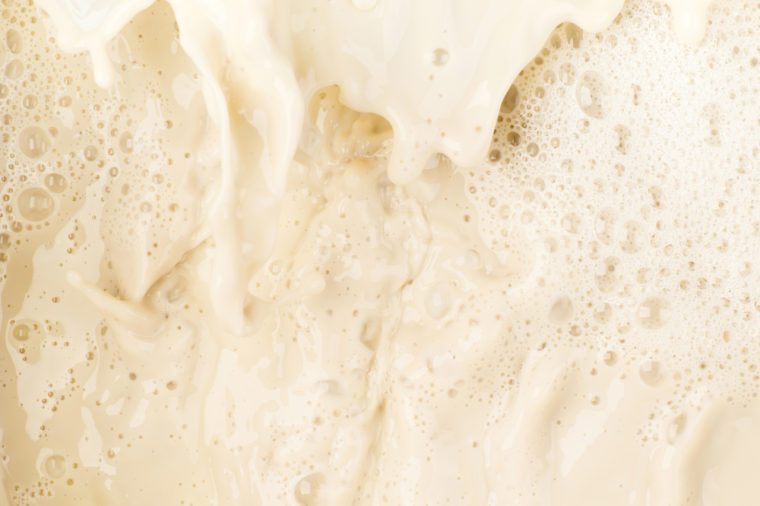 Soy milk splash and bubble foam on top view food and drink background close up