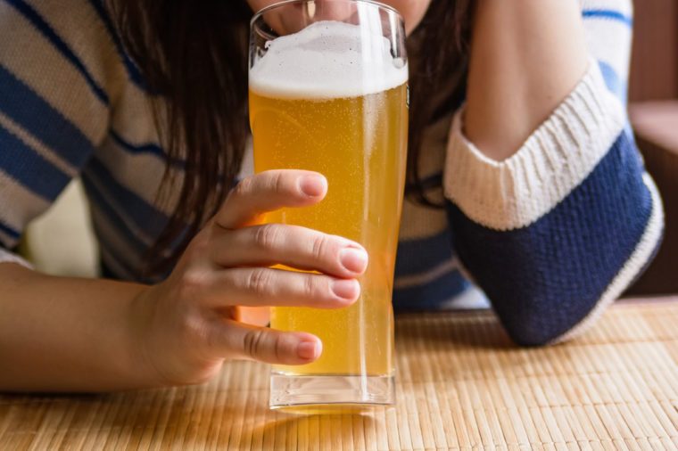 Young woman drinks beer