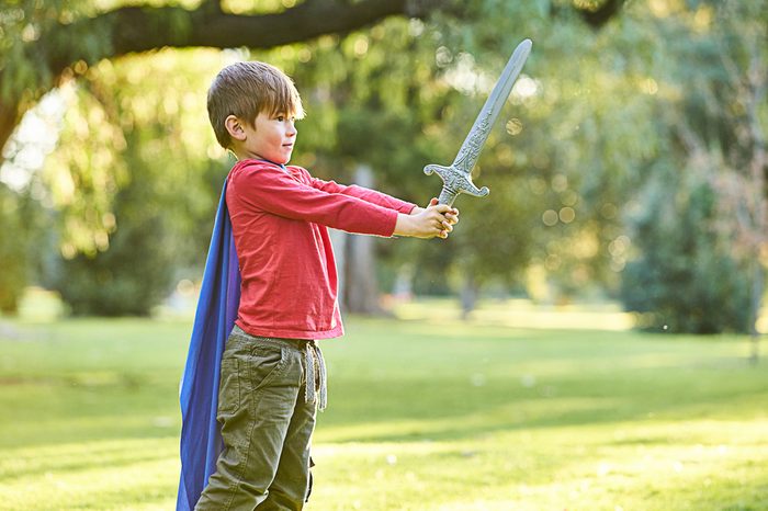 boy playing with toy sword in park