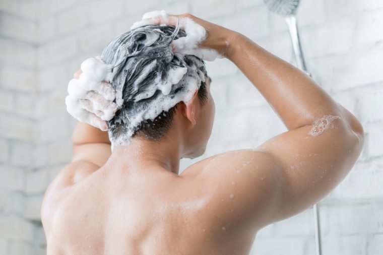 The man is washing his hair, he use shampoo.