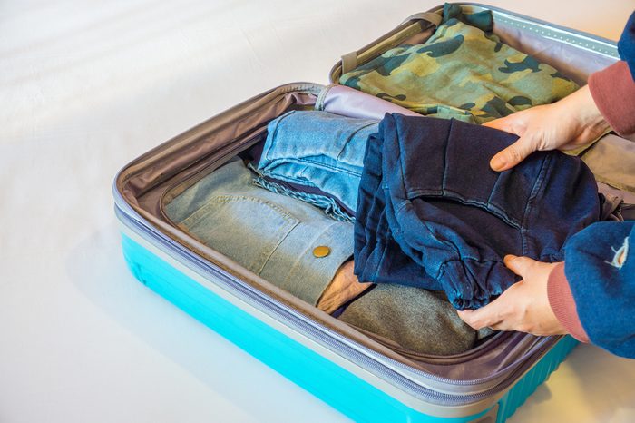 Someone is packing clothes in baggage. It does help to reduce wrinkling.