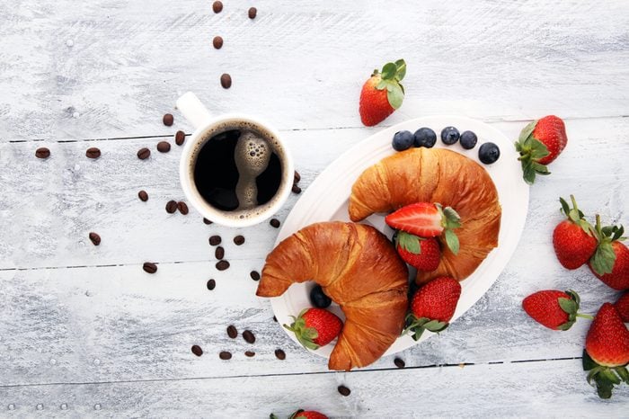 coffee and croissant with coffee beans. breakfast energy concept