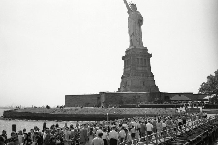 Visitors leaving the pier pass those moving toward the base of the Statue of Liberty on Bedloe's Island in New York's harbor on . Summer week-ends are especially busy, as tourists crowd the excursion boats which travel to the island from the foot of Manhattan Island