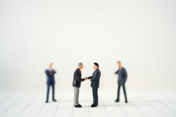 Miniature businessman handshake with success deal business using as background commitment, agreement, investment and partnership concept
