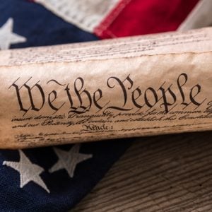 United States Constitution, rolled in a scroll on a vintage American flag and rustic wooden board