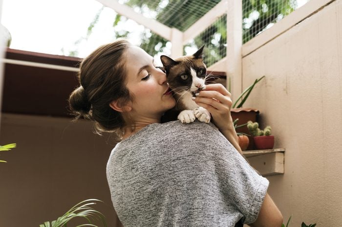 Woman holding and kissing her cat