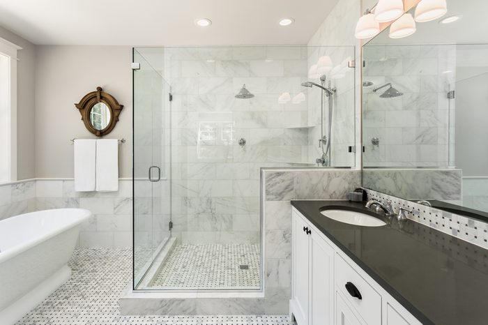 Master bathroom in new luxury home: Bathtub and shower with tile and glass shower doors