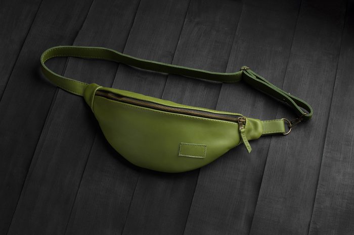 green leather fanny pack on black background