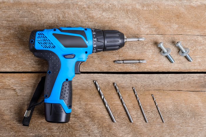 Close up Electric drill, Drill set, Screwdriver set, adapter on wooden table background and copy space. Hammer drill or screwdriver, Electric cordless hand drill on wooden. maintenance home concept.