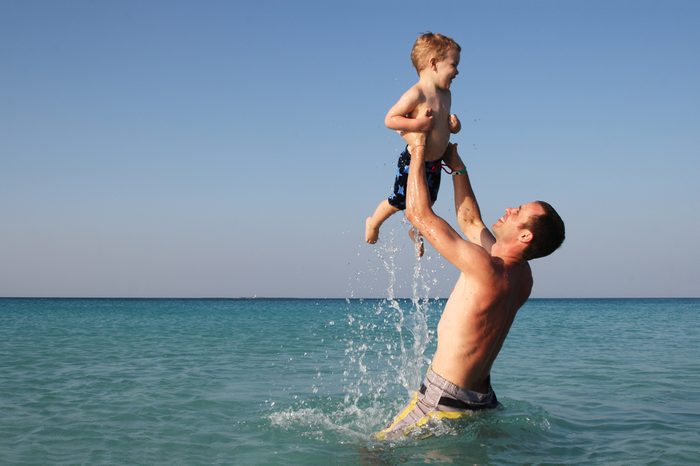 Father and son playing in the ocean