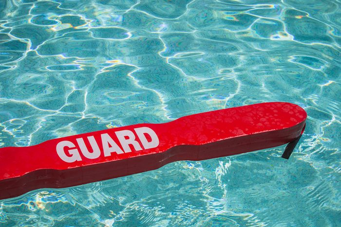 A close up shot of a life guards red rescue tube floating in a pool.