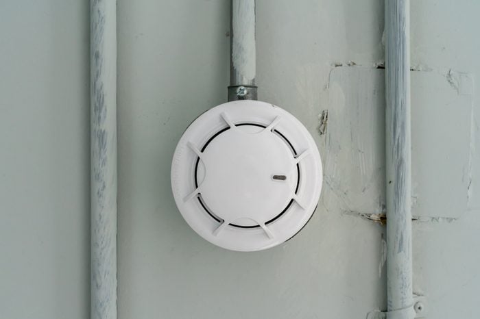 Smoke detector sensor on cement ceiling in parking area