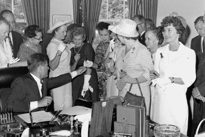 President Kennedy passes out pens, at the White House after signing a bill to provide equal pay for women. From left: Ethlyn Christensen of the YWCA; Rep. Leonor Sullivan, D-MO; Mrs. Joseph Willen of the National Council of Jewish Women; Rep. Edna Kelly, D-NY; Margaret Mealey, foreground, checkered dress, of the National Council of Catholic Women; Rep. Edith Green, D-OR; and Mrs. Carolyn Davis of the United Auto Workers