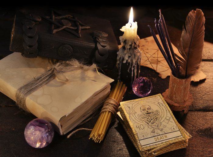 Still life with magic objects, books, candles and the tarot cards. Halloween and magic still life, fortune telling seance or black magic ritual with mysterious occult and esoteric symbols 