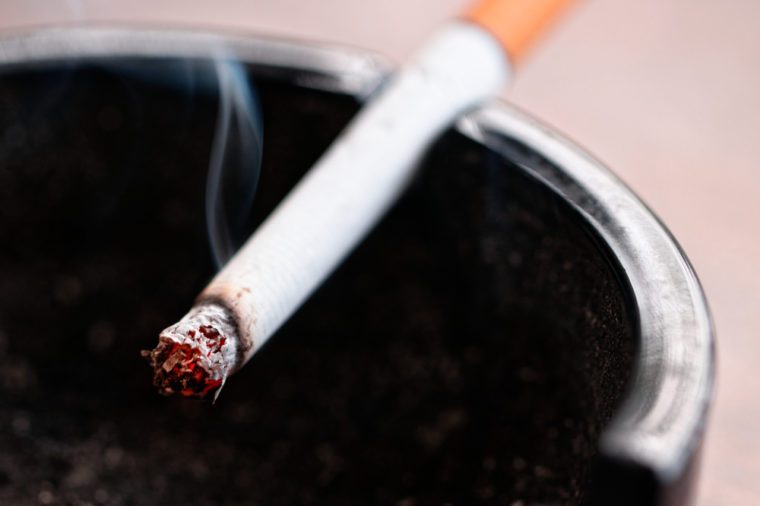 close up, macro shot of a burning cigarette in an ashtray