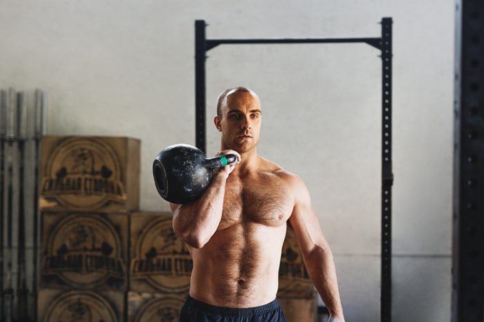 Fitness man doing exercises with kettlebell in gym