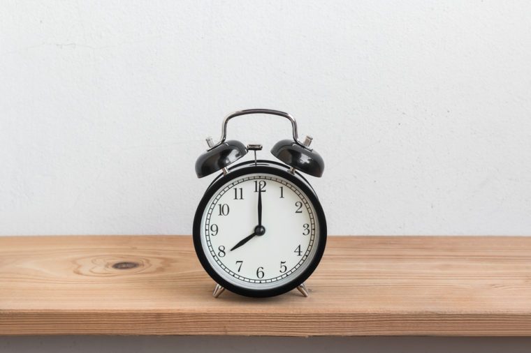 Vintage alarm clock on wood shelf ( alarm clock show 8 o`clock )