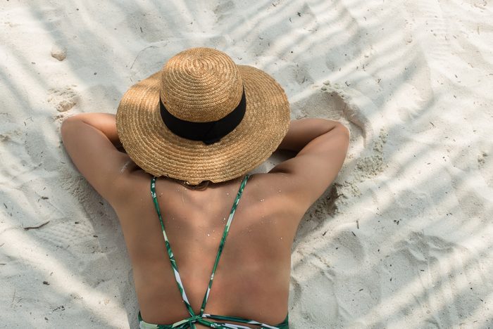 beautiful girl in green bikini on the white sand maldivian palm beach, top view, model view