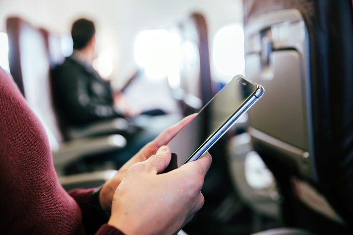 Man using a smartphone in an aircraft.