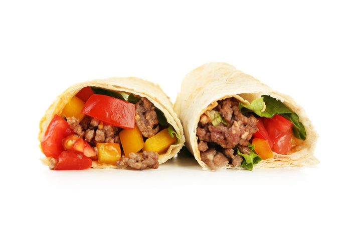 Homemade beef burrito with vegetables and tortilla, isolated on white