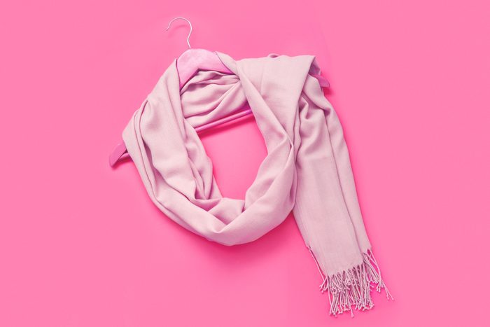 large scarf wrap on a hanger on a pink background
