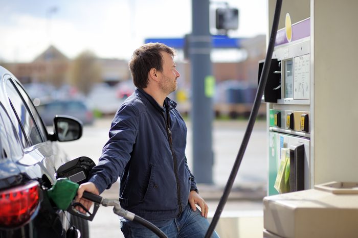 Man filling gasoline fuel in car holding nozzle